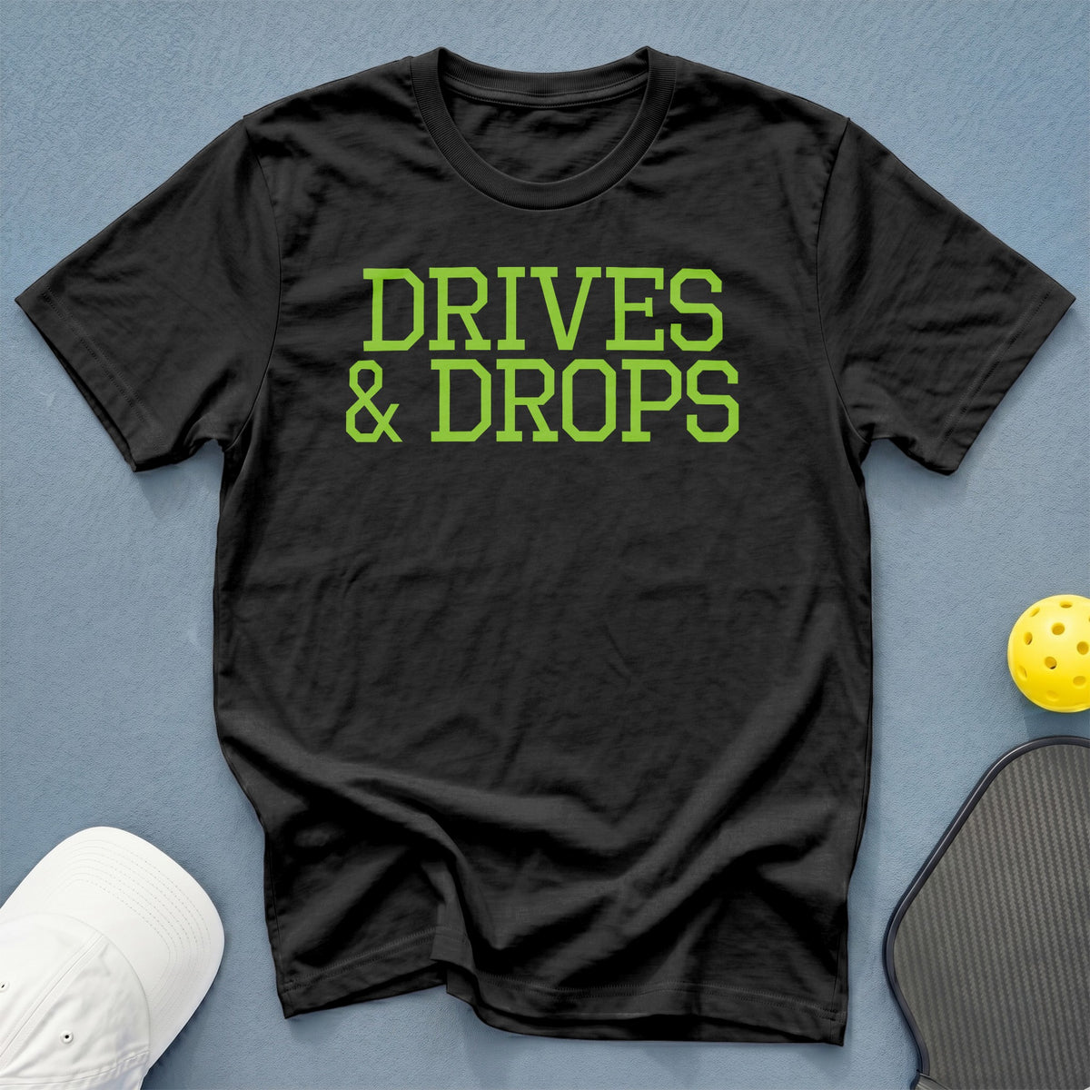 Black t-shirt with green text that says "DRIVES & DROPS".