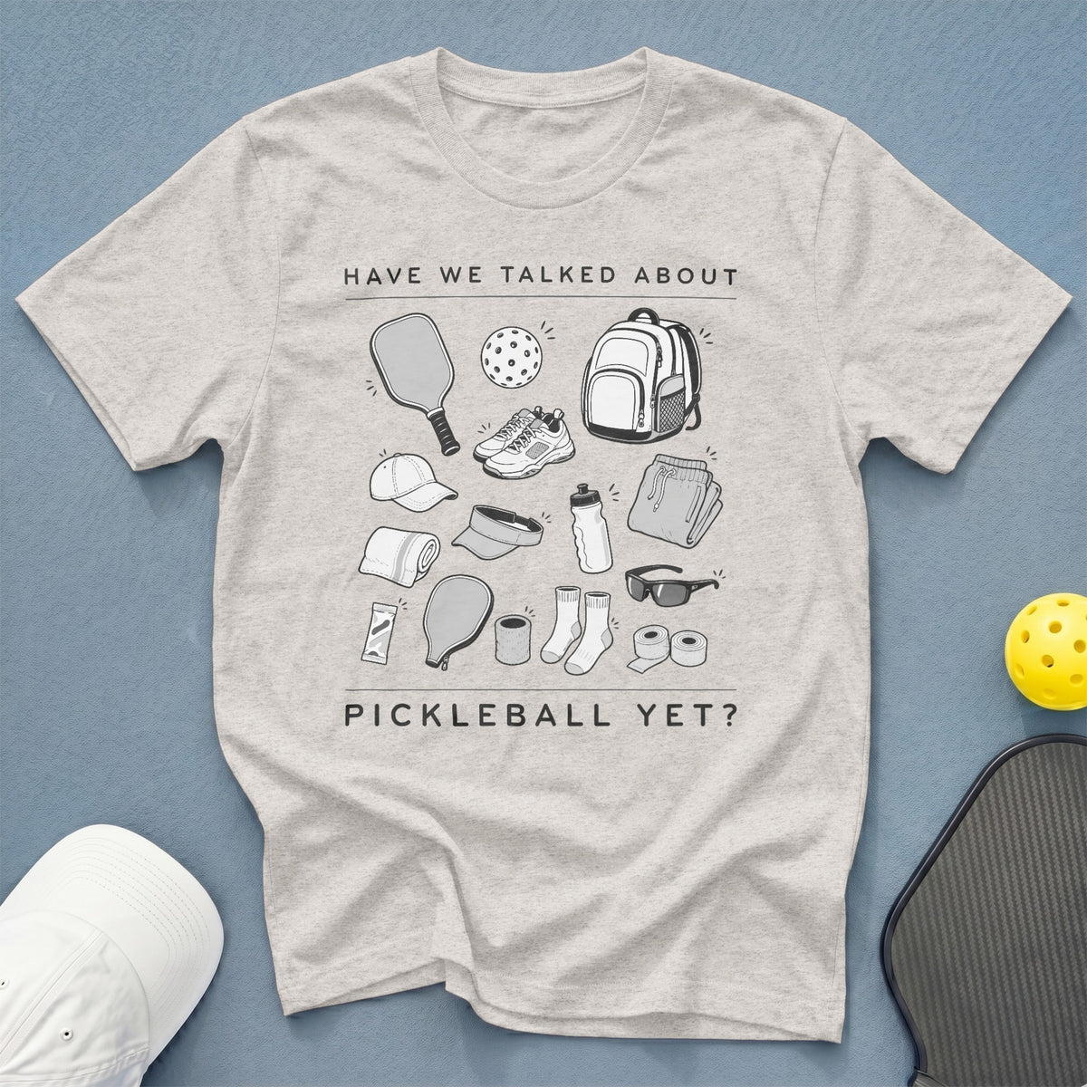 Light gray t-shirt with a graphic of pickleball gear and the text "HAVE WE TALKED ABOUT PICKLEBALL YET?".