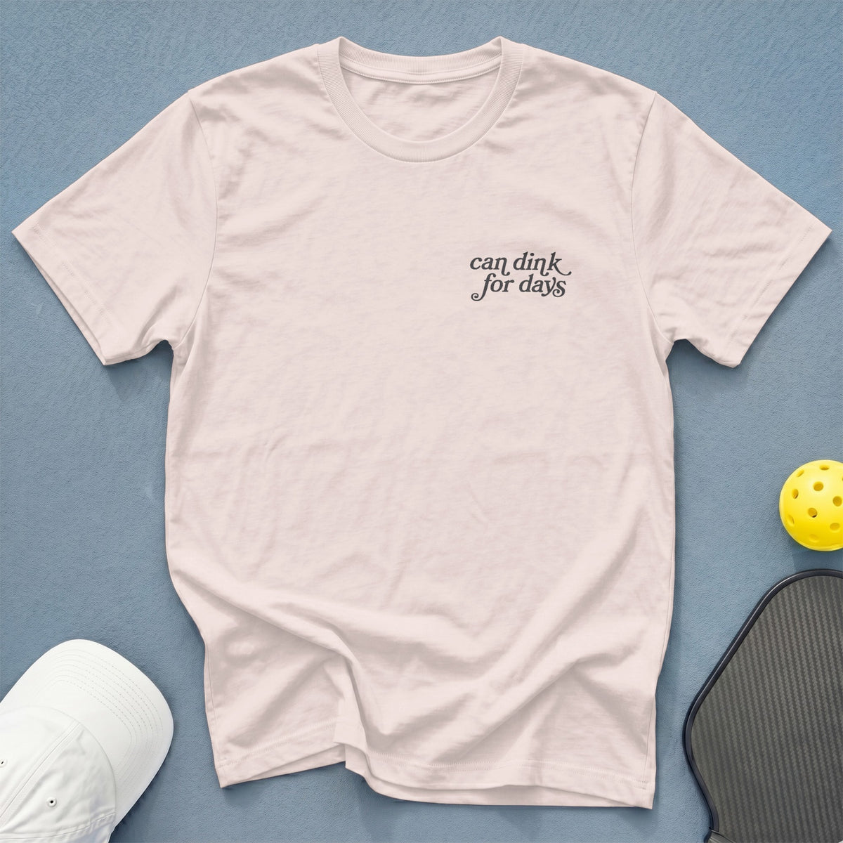 Light pink t-shirt with "can dink for days" graphic, pickleball paddle, and ball.
