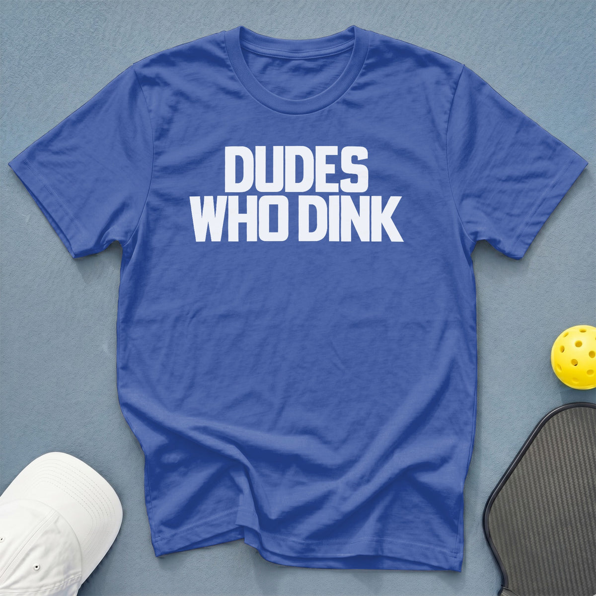 Blue t-shirt with white text "DUDE WHO DINK", pickleball paddle, and ball.