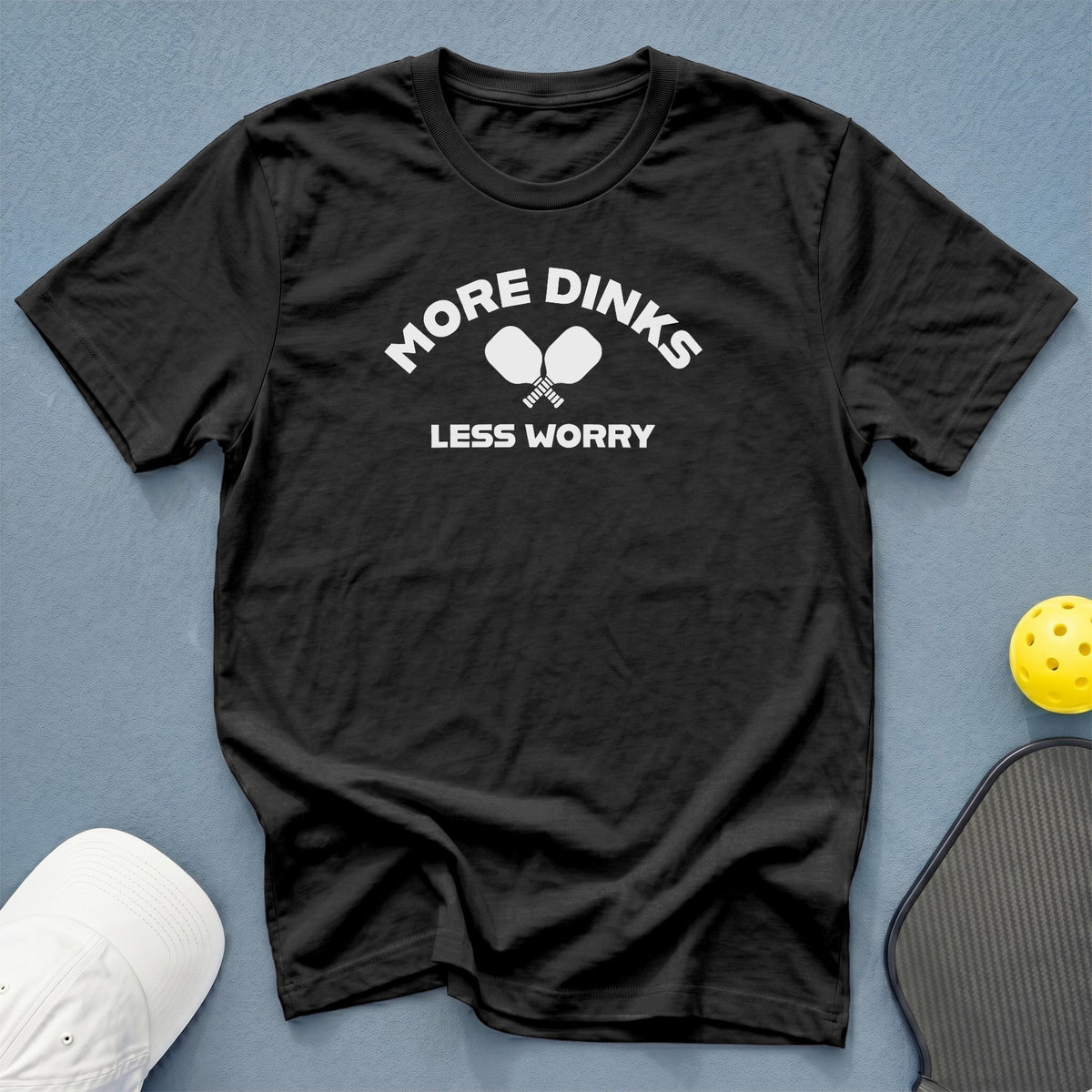 Black t-shirt with "More Dinks Less Worry" and pickleball paddles graphic.