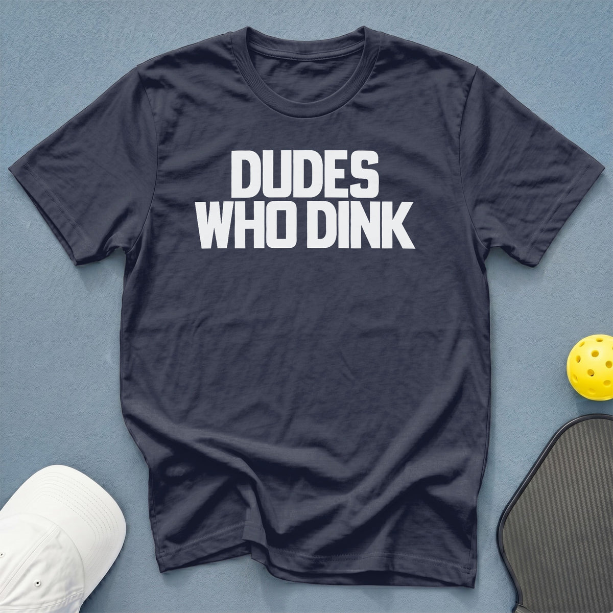 Navy t-shirt with white text "DUDE WHO DINK", pickleball paddle, and ball.