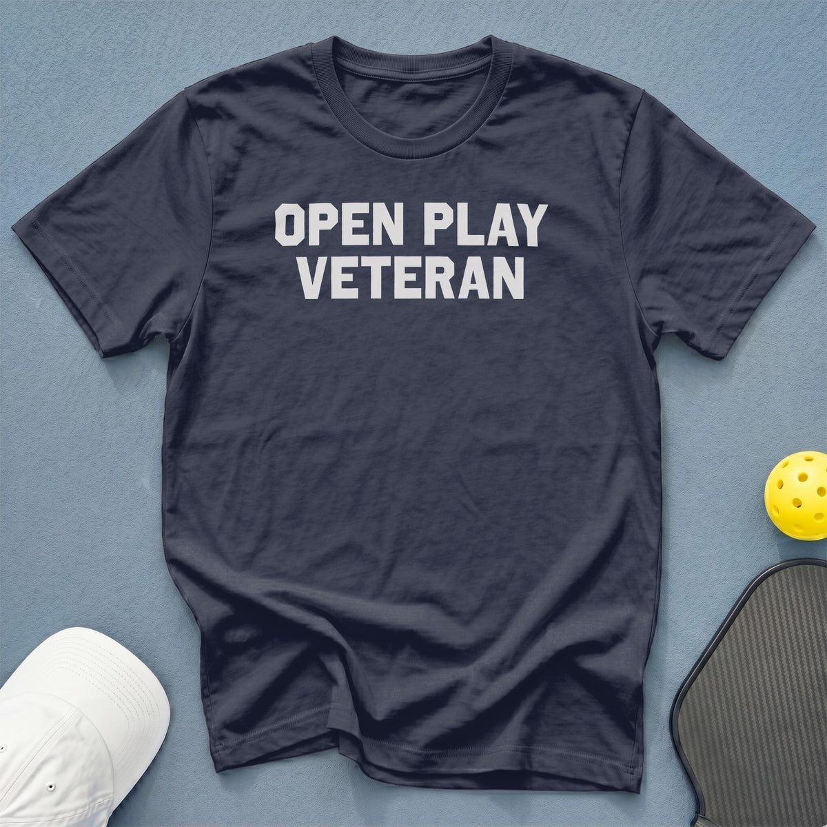 Dark navy t-shirt with "OPEN PLAY VETERAN" in white block letters.