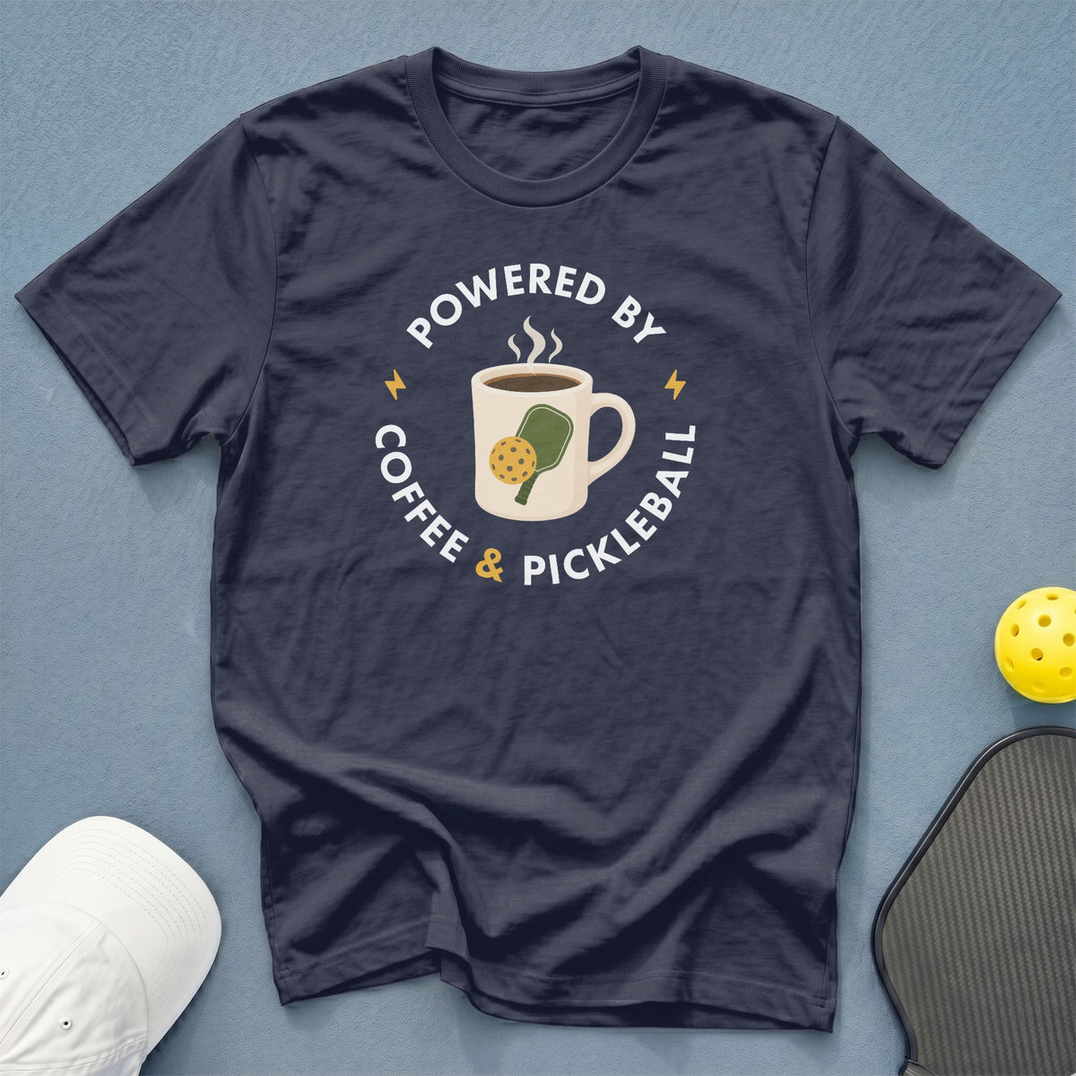 Navy t-shirt with "Powered by Coffee & Pickleball" graphic and coffee mug design.