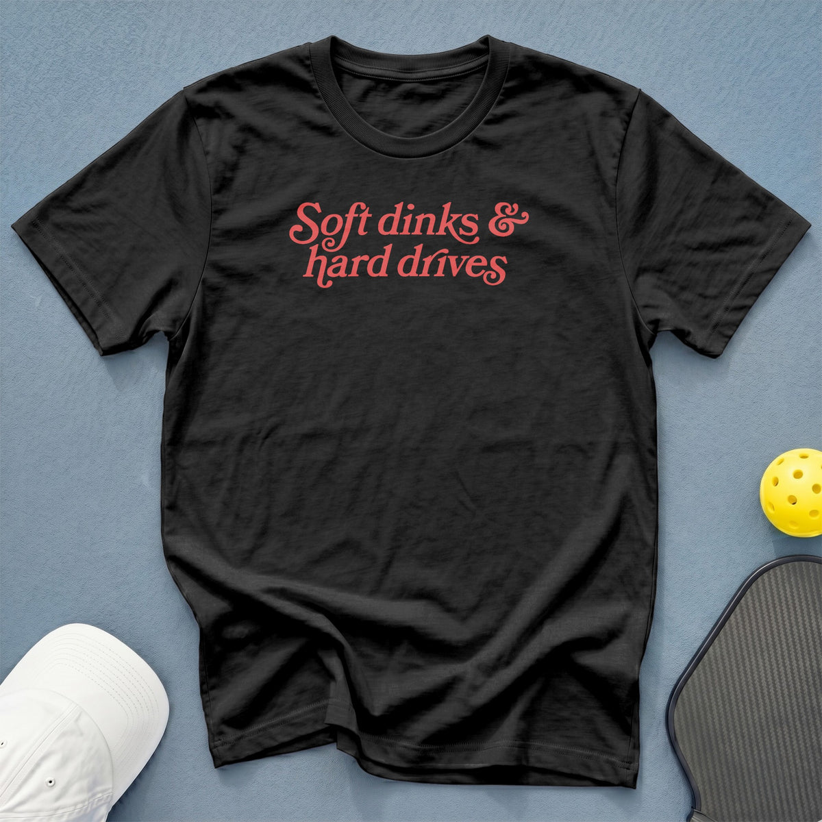 Black t-shirt with coral text reading "Soft dinks & hard drives".