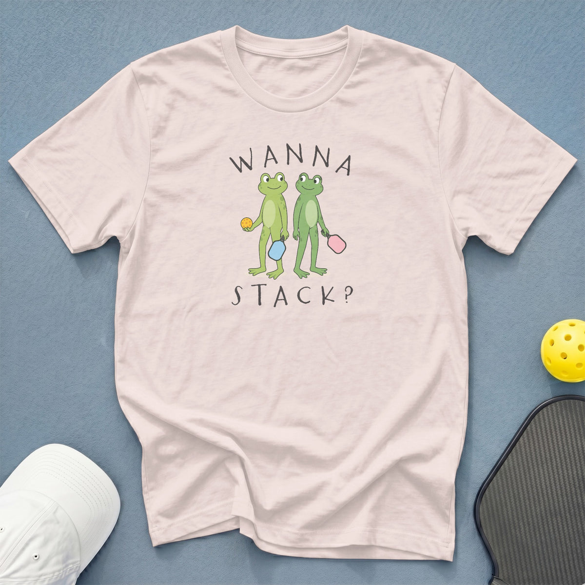 Light pink t-shirt with two frogs holding pickleball paddles and balls, text WANNA STACK?