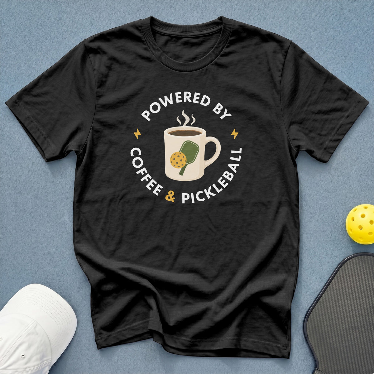 Black t-shirt with "Powered by Coffee & Pickleball" graphic featuring a coffee mug and pickleball paddle.
