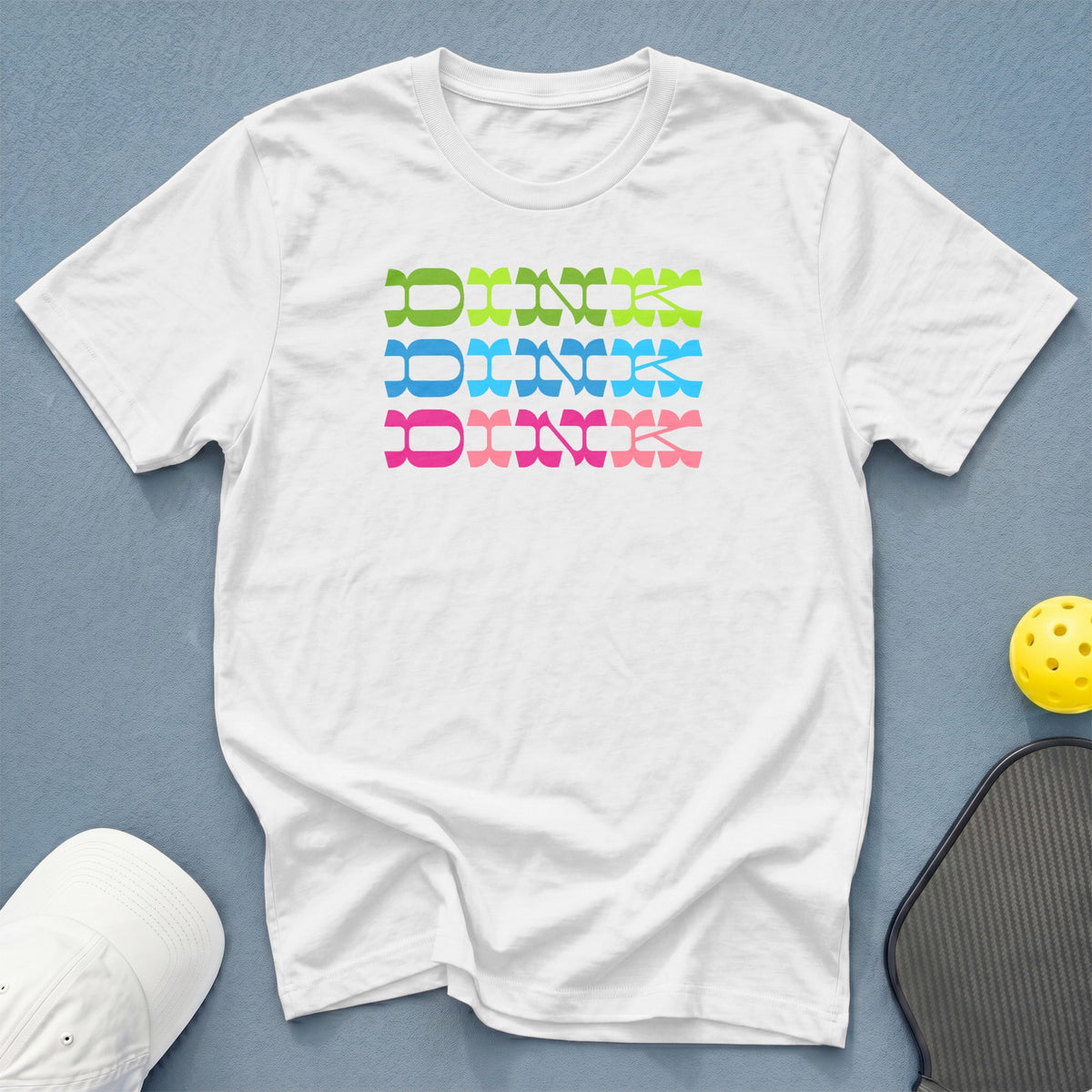 White t-shirt with "DINK" in green, blue, and pink stacked text.