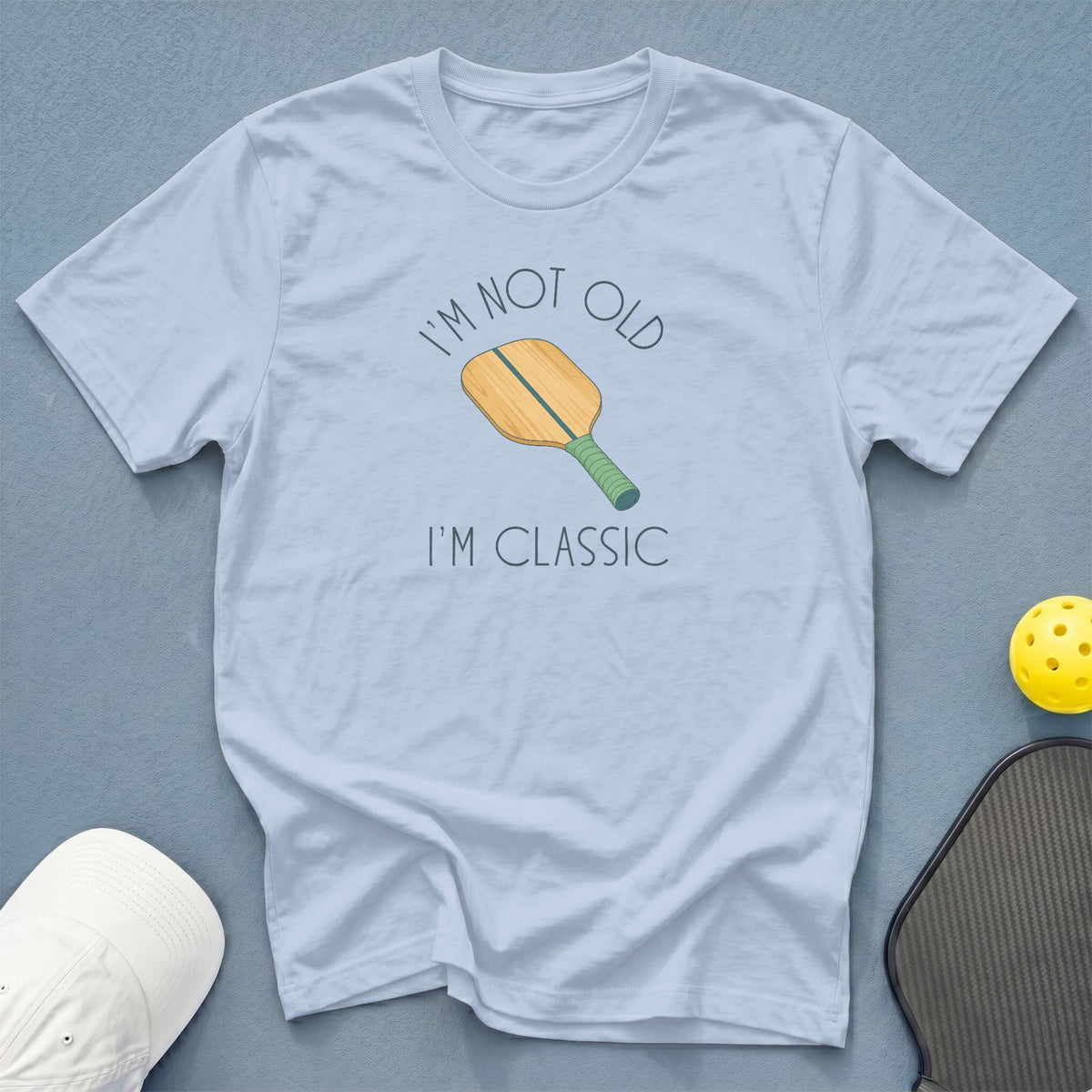 Light blue t-shirt with a pickleball paddle and text "I'M NOT OLD I'M CLASSIC."