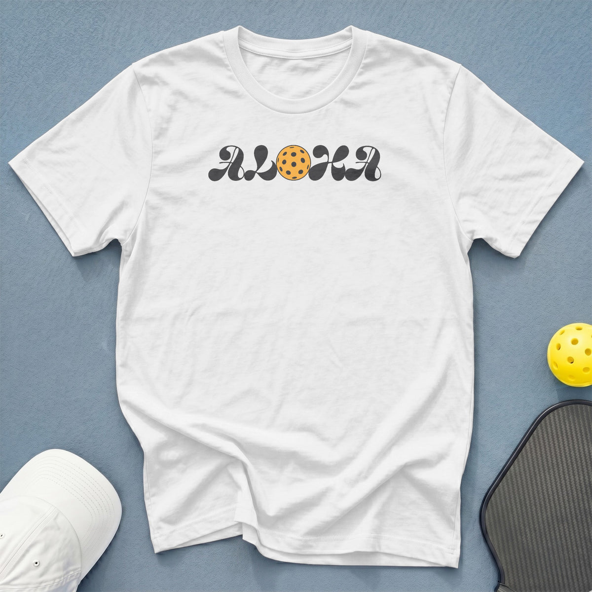 White t-shirt with retro "ALOHA" text and pickleball graphic.