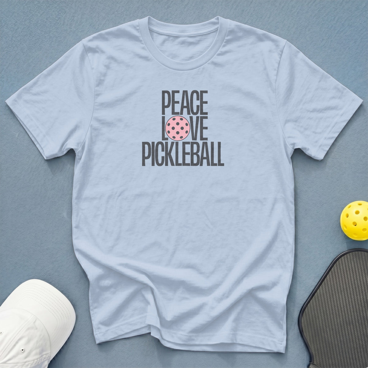 Light blue t-shirt with "Peace Love Pickleball" graphic, pickleball, and paddle.