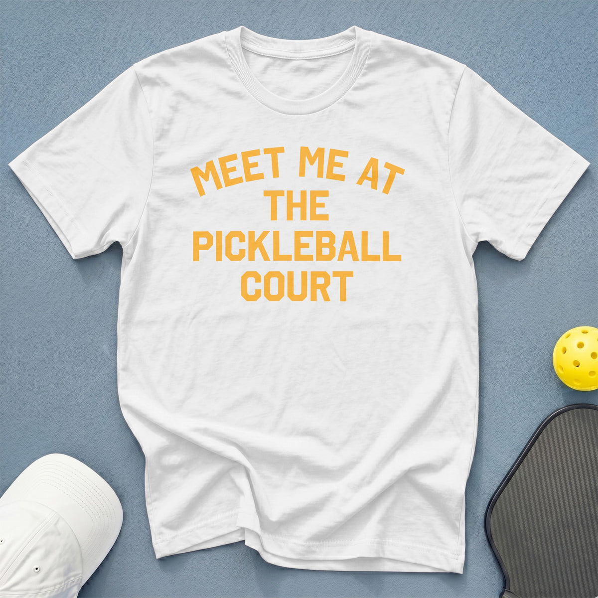 White t-shirt with "Meet me at the pickleball court" printed in orange.