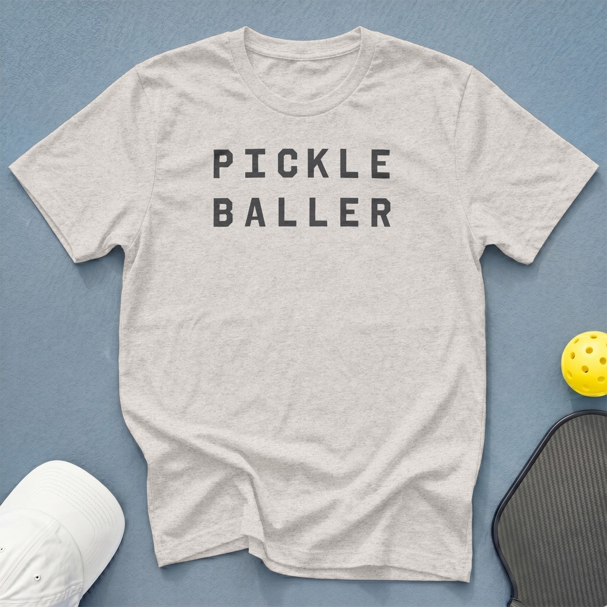 Light grey t-shirt with "PICKLE BALLER" text, pickleball, and paddle.
