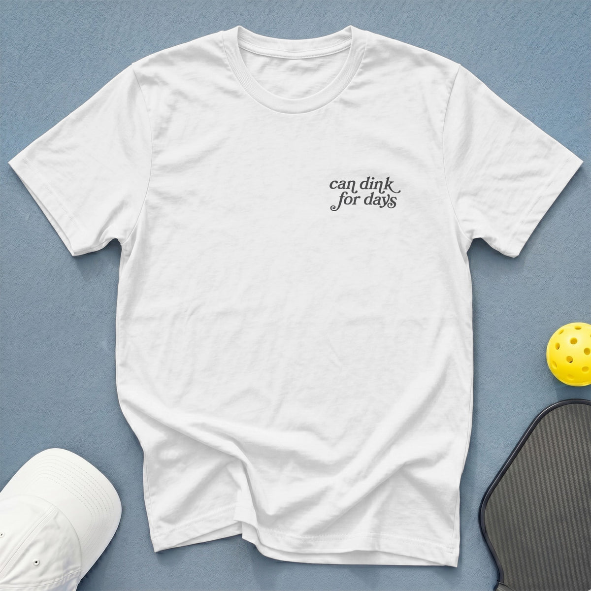 White t-shirt with "can dink for days" text, pickleball paddle, and ball.