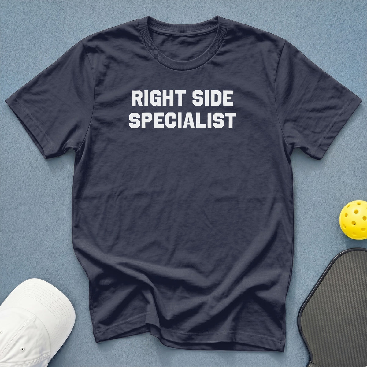 Dark blue t-shirt with white text "RIGHT SIDE SPECIALIST" and pickleball gear.