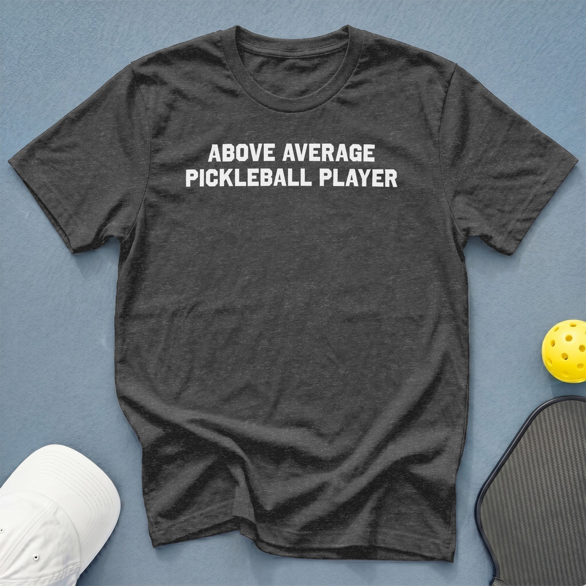 Dark grey t-shirt with white text "ABOVE AVERAGE PICKLEBALL PLAYER".