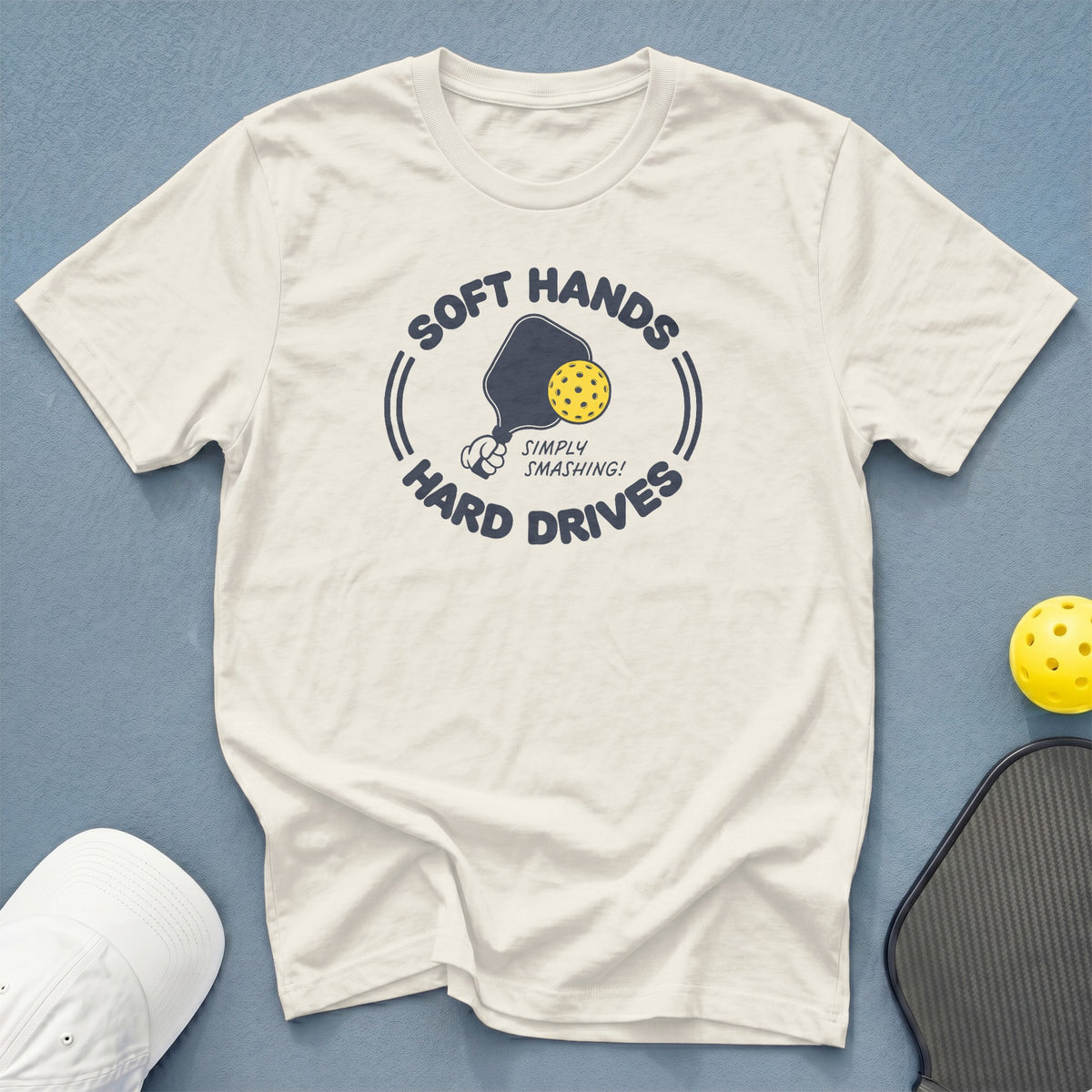 Cream t-shirt with a pickleball paddle, ball, and text: "Soft Hands, Hard Drives".